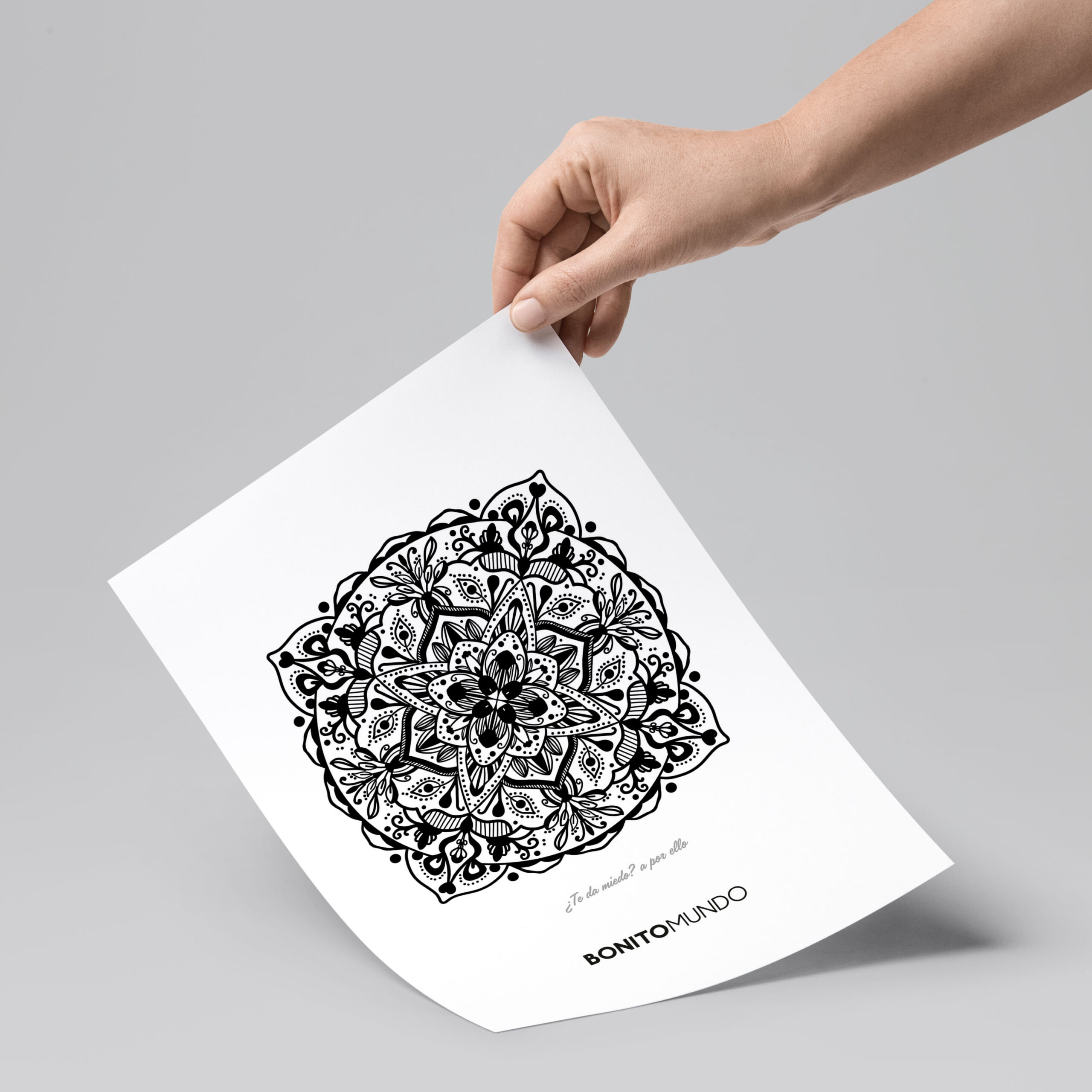 hand holding sheet with mandala