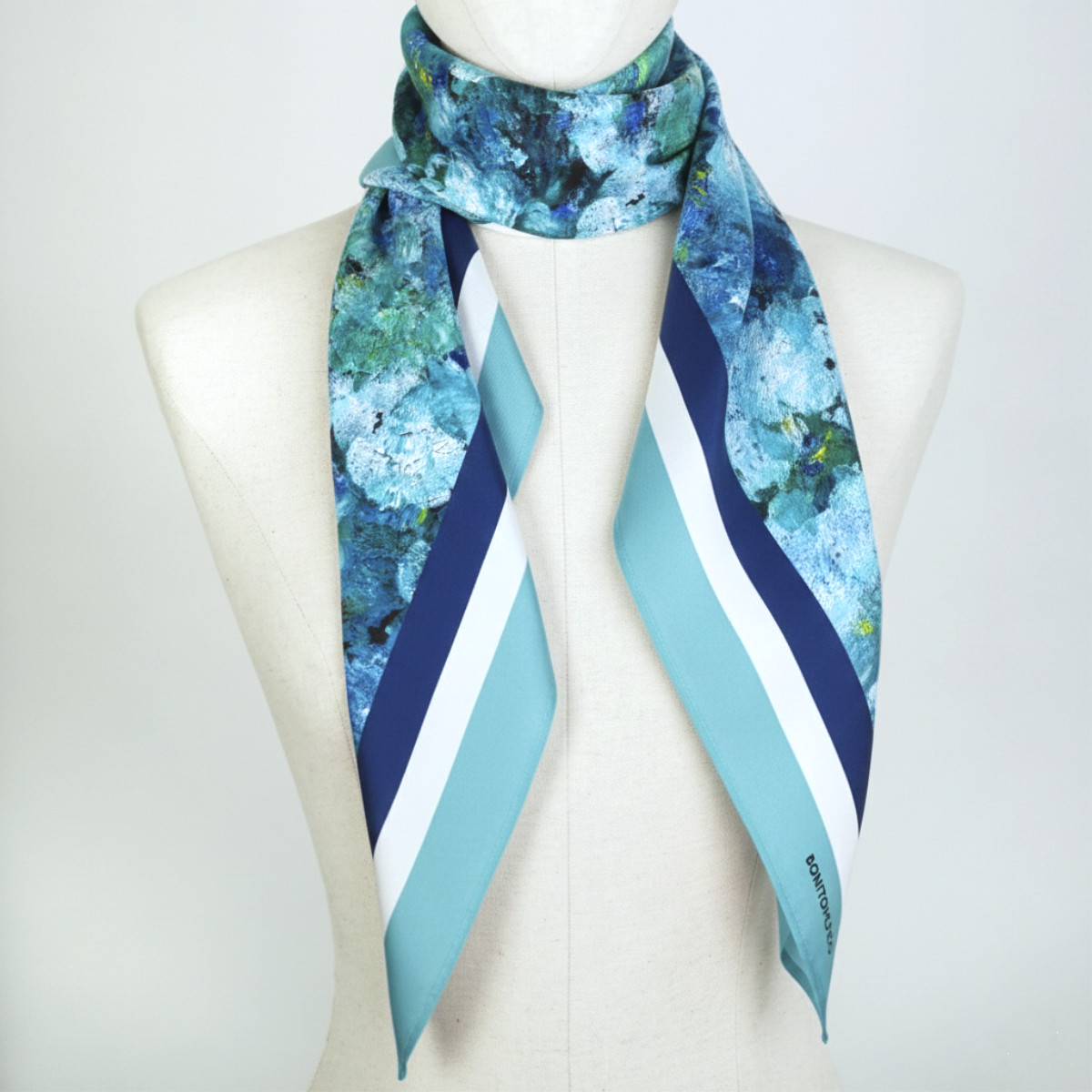 pañuelo de seda turquesa estampado al cuello de maniqui